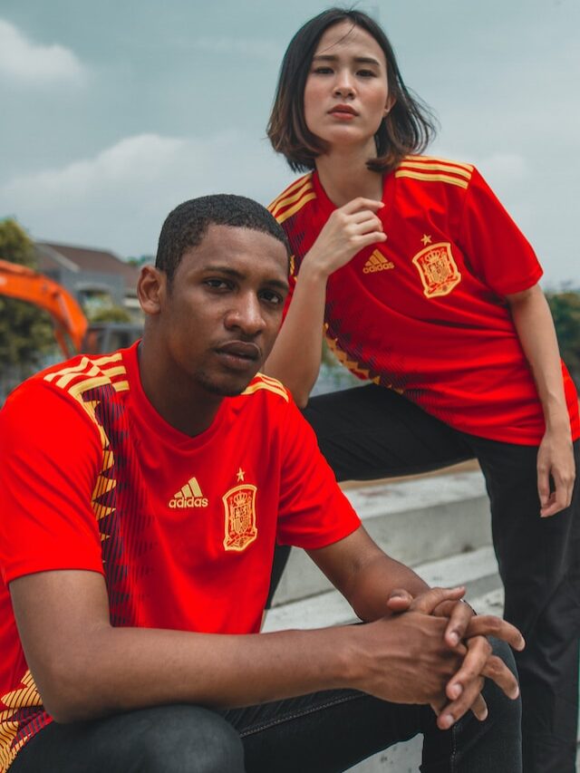 man and a woman wearing spain football shirt